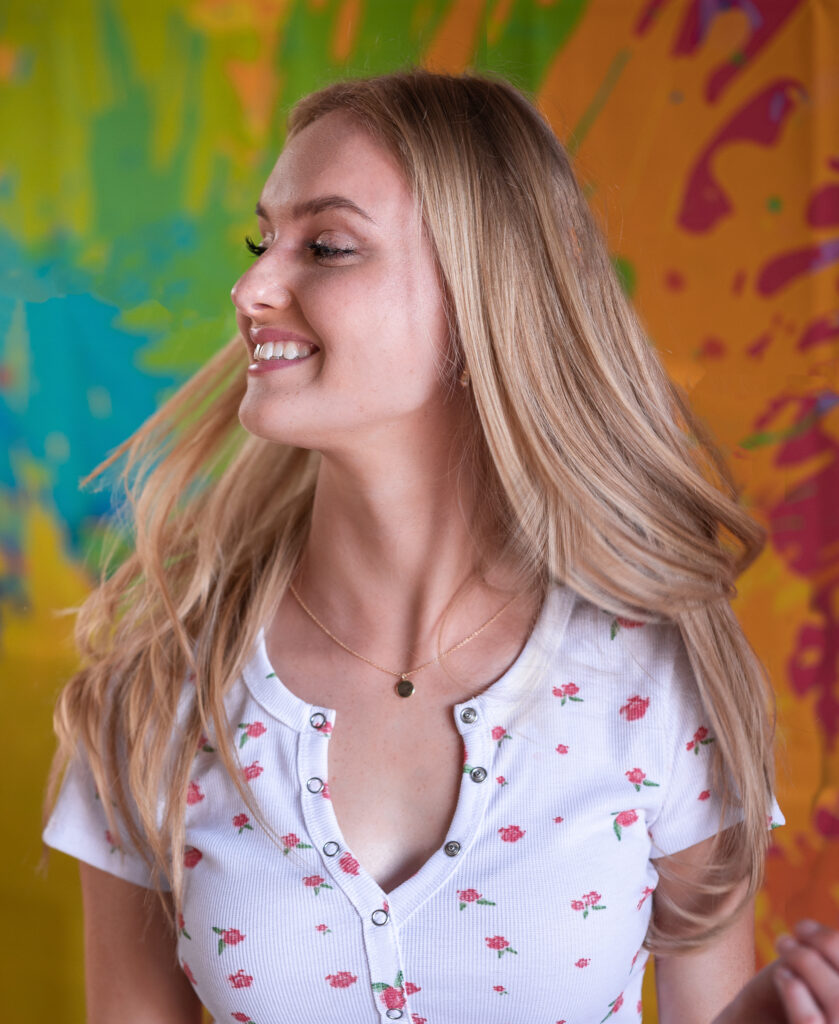 teenager girl moving her head from side to side and smiling during her senior photoshoot with Elizabeth Klusmann Photography